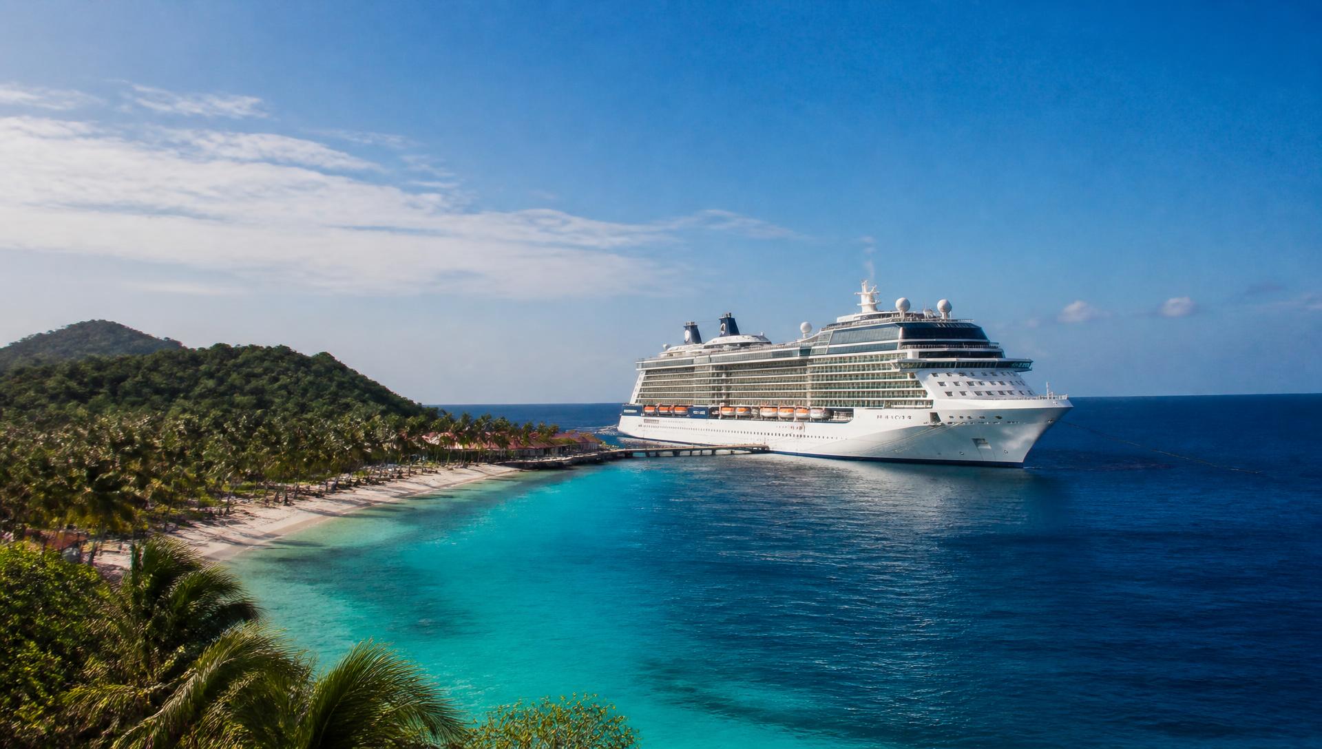 A modern cruise ship anchored off a lush Caribbean private island in bright daylight